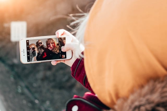 Couple taking a selfie on using an AI photo editing app for iPhone to capture and enhance photos outdoors