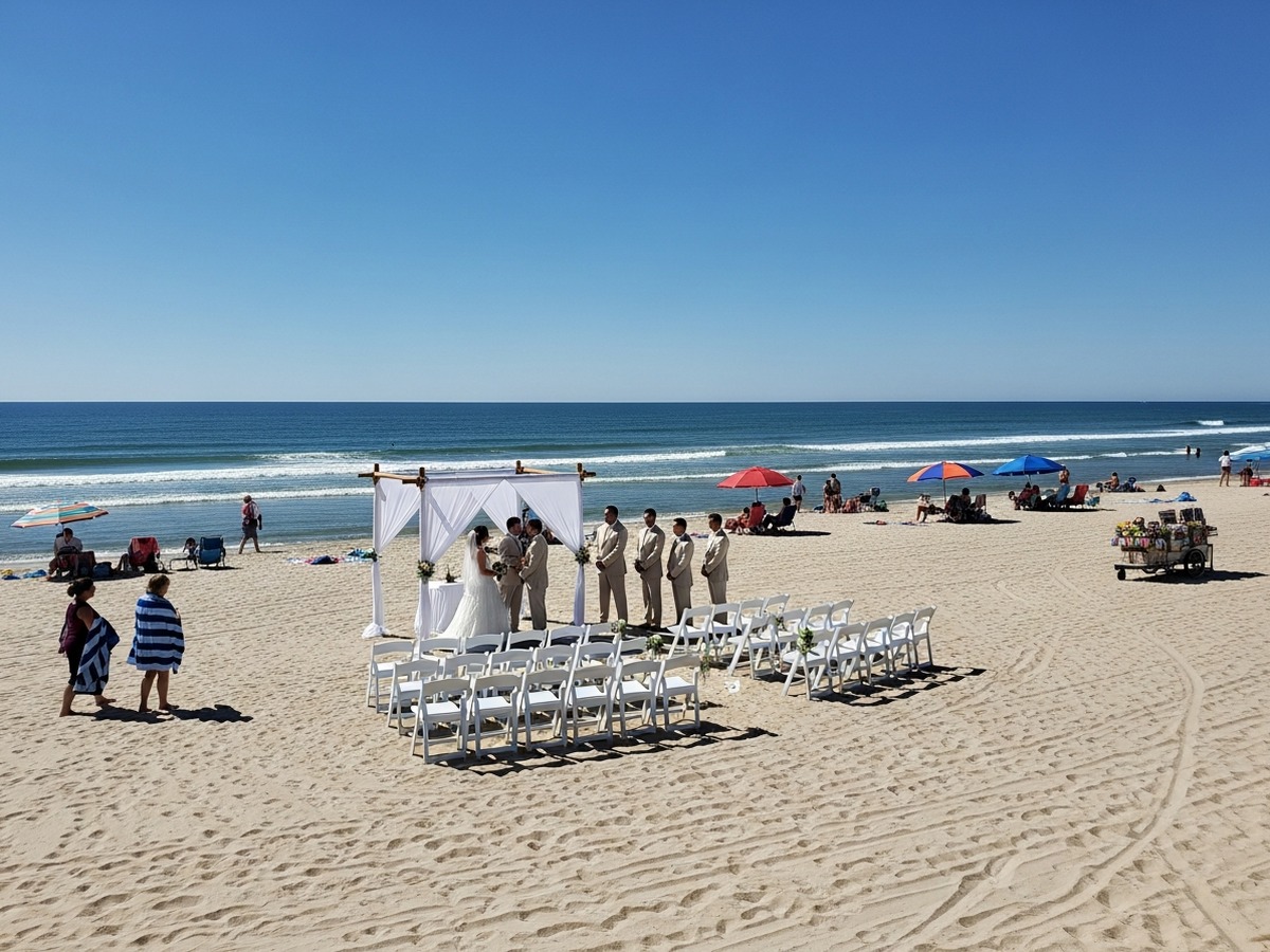 Escena real de boda en la playa con arena brillante y fondo público