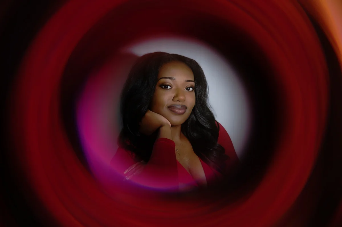 Creative portrait by Crystal Monique shot through a swirling red light tunnel