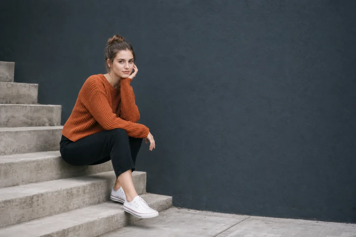 Portrait with a warm sweater balanced by a large cool-toned wall and negative space