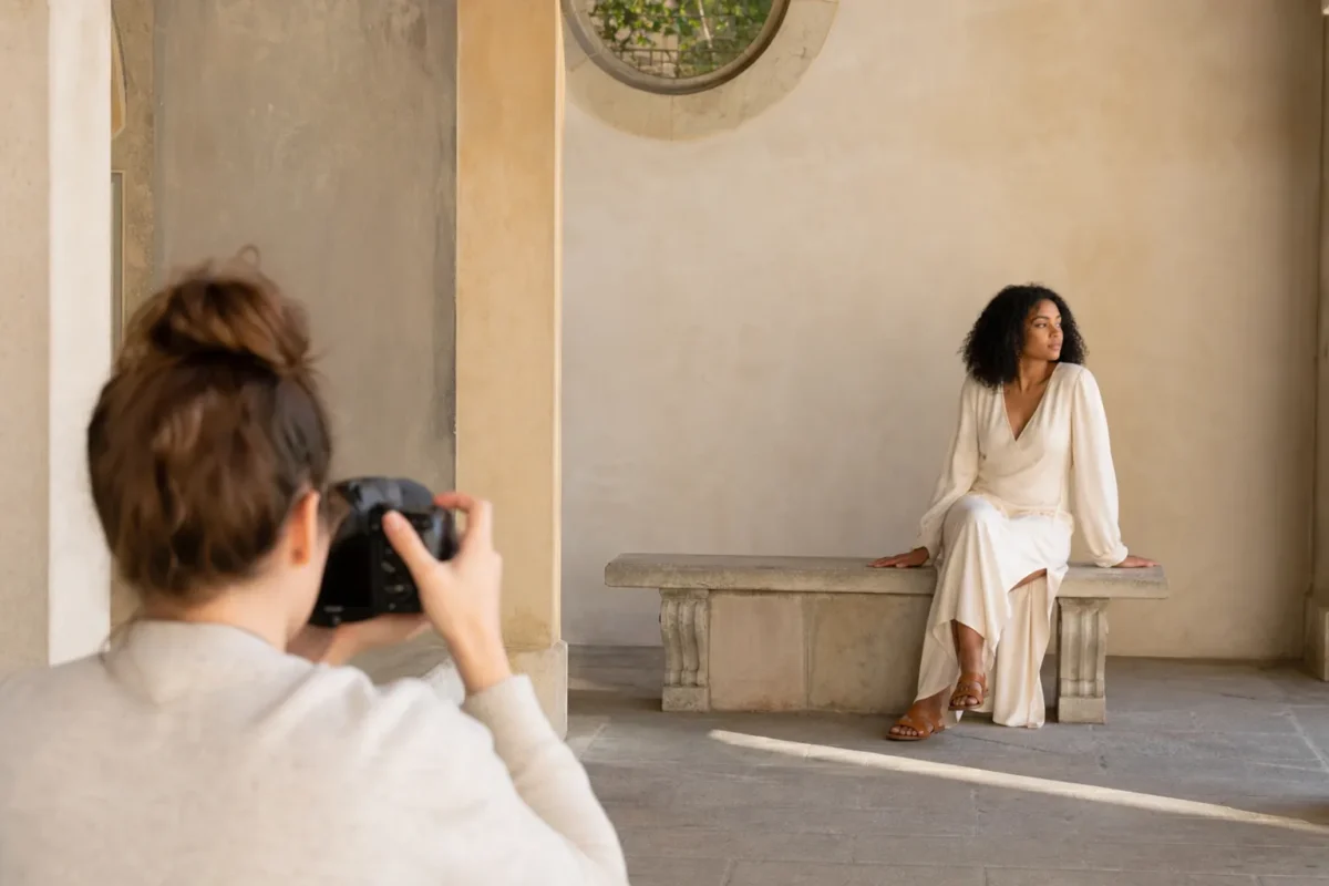 Photographer composing an off-center portrait with balanced negative space in an architectural courtyard