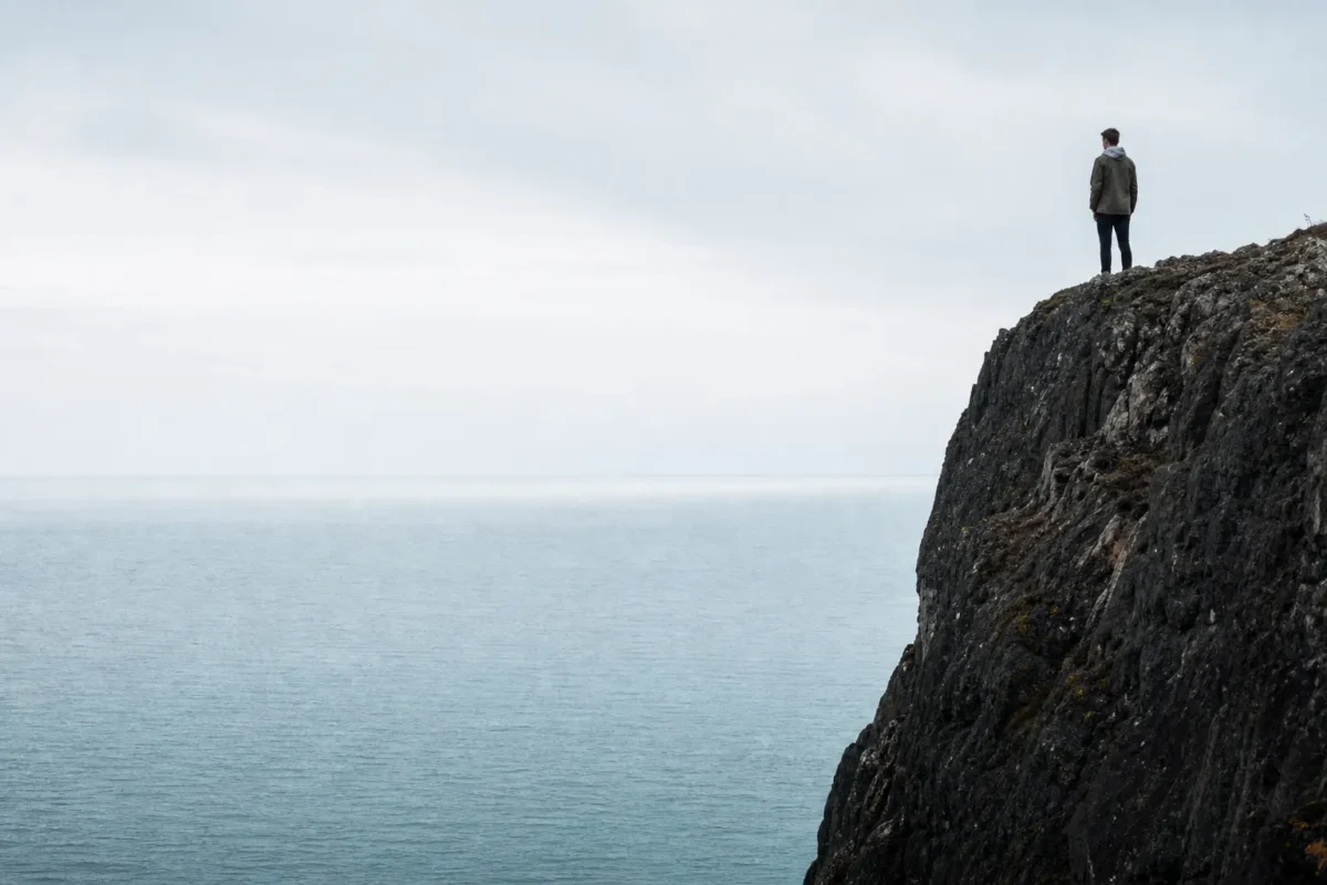 Lone subject placed near the edge of a cliff frame to create intentional imbalance