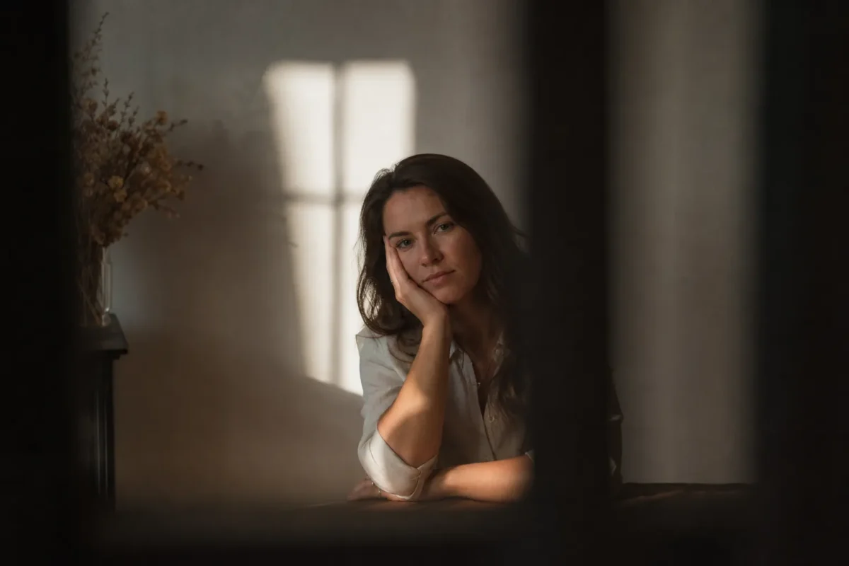 Portrait subject framed by window light and darker shadowed edge