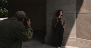 Photographer composing a subject in strong light and shadow to control contrast