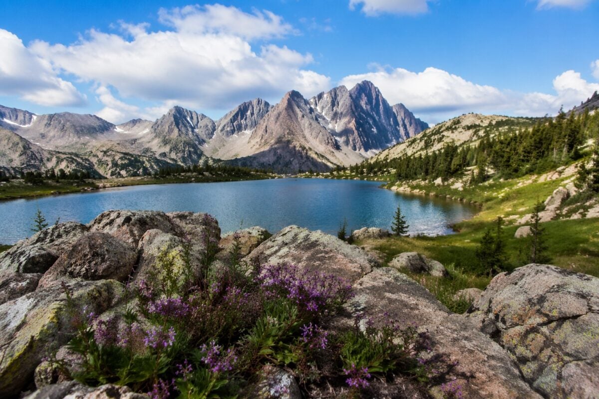 Landscape with foreground rocks, middle-ground water, and distant mountains creating clear depth