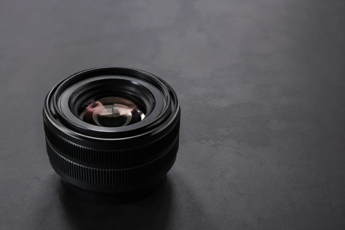 Camera detail photographed on a clean surface with negative space for layout