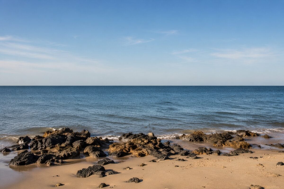 Simple coastal landscape showing a clear level horizon line dividing sky and water