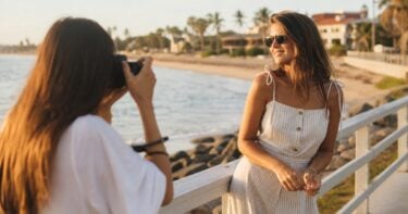 Photographer capturing a relaxed summer portrait near the beach in warm evening light