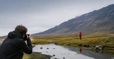Photographer composing a scene where a red subject carries strong visual weight in a quiet landscape