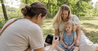Photographer adjusting camera settings during a natural child portrait session