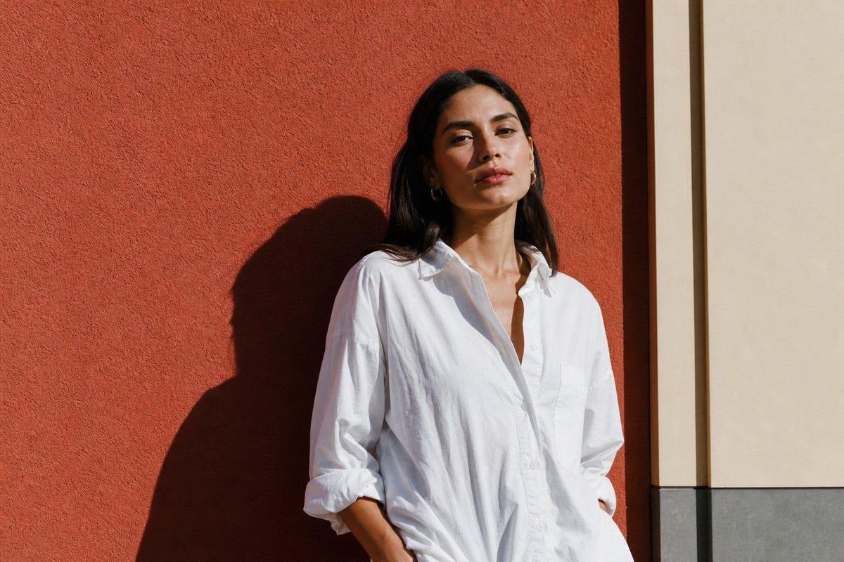 Editorial portrait using hard midday sun, strong shadow shape, and controlled skin highlights