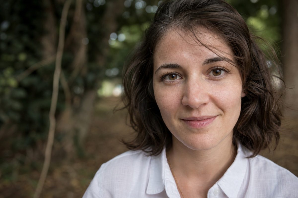 Outdoor portrait close-up showing readable eye, hair, and fabric edges after a controlled Photoshop sharpening pass