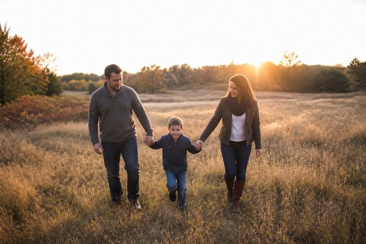Family walking an open autumn field in low late-day light with room to move